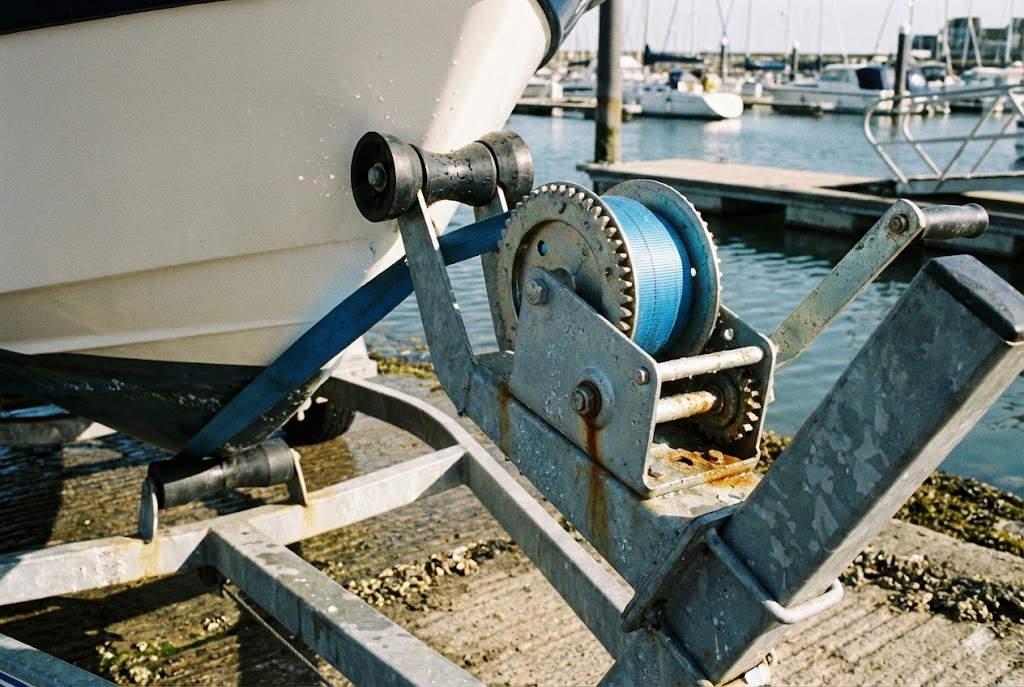 Argano manuale in azione mentre tira una barca sul carrello sullo scivolo.