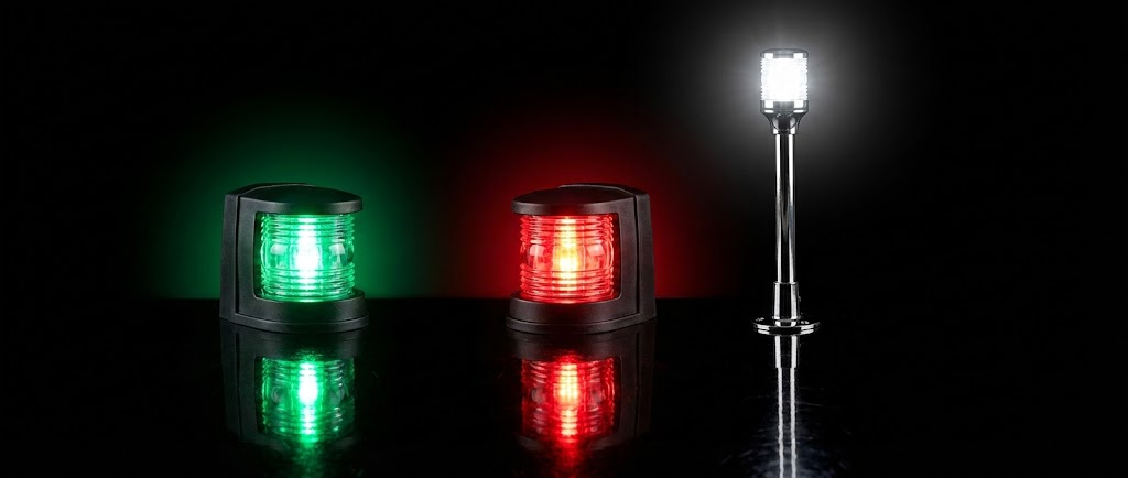 Un potente faro di profondità nautico acceso puntato verso l'esterno, affiancato da una moderna luce subacquea a LED blu accesa che simula l'effetto in acqua.