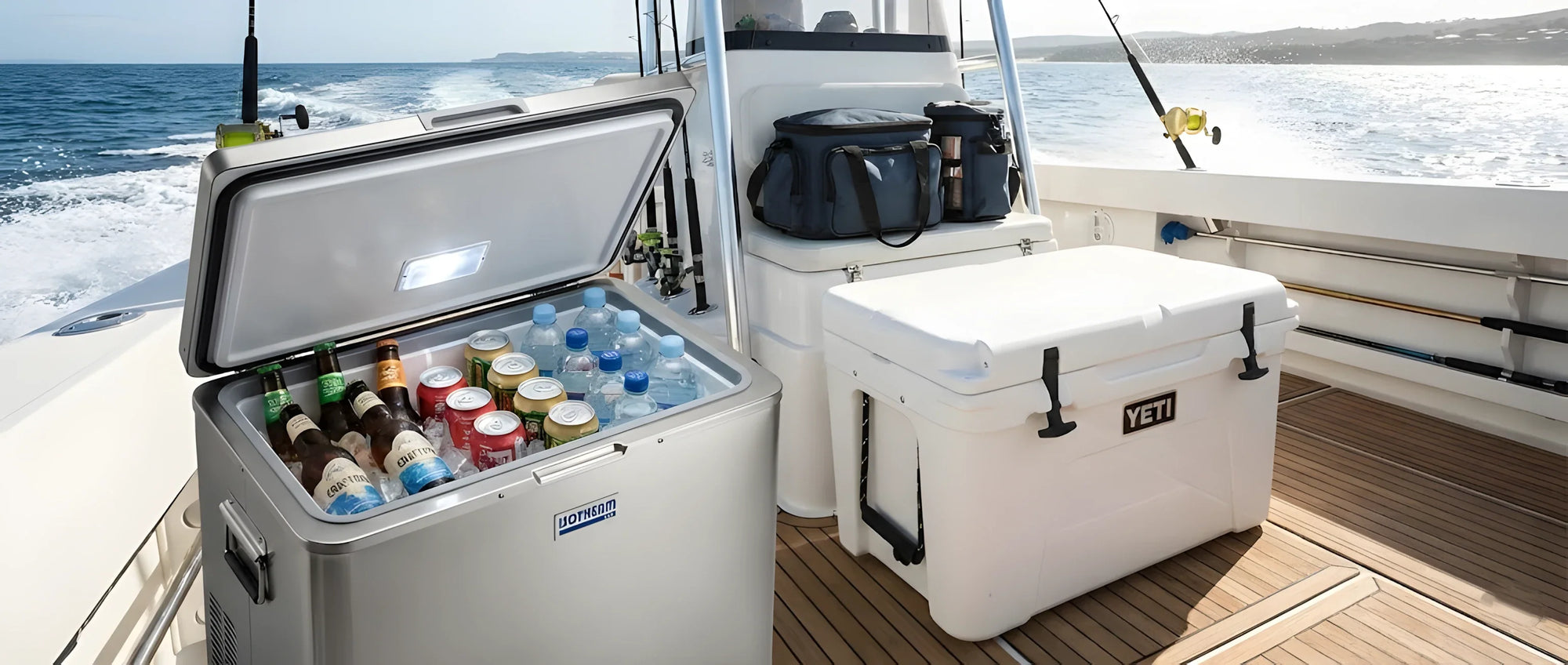 Un frigorifero nautico in acciaio inox aperto con bevande fresche, accanto a una robusta ghiacciaia bianca portatile chiusa.