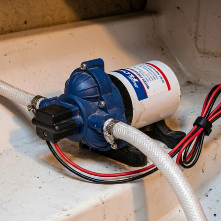 Autoclave SuperFlow Osculati 12V installata a bordo nel gavone, impianto acqua in pressione con manichette e cablaggio