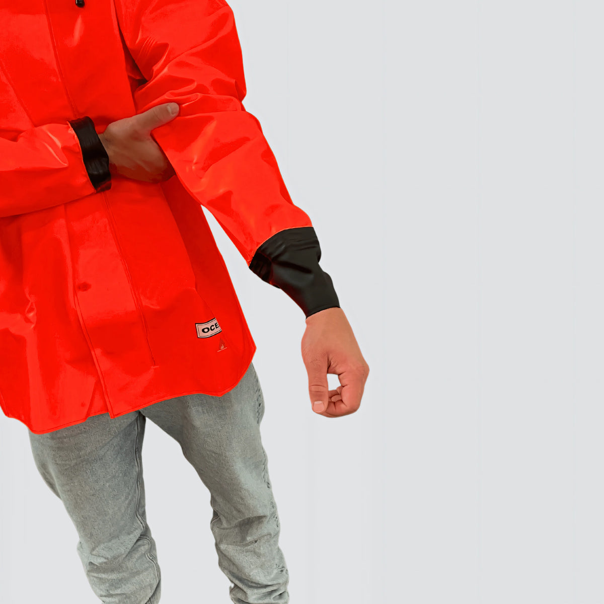 Giacca antipioggia OCEAN Offshore Heavy arancio fluo in PVC 560 g/m² con cappuccio grande e polsini in gomma, dettaglio del polsino in gomma